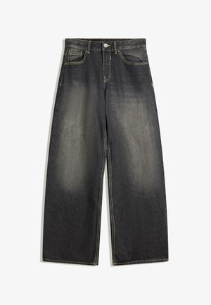 Čierne široké rifle so svetlým predným vyblednutím, päťvreckový štýl, žlté prešívanie a zapínanie na gombík v páse.