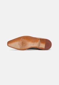 Sole di scarpa in pelle marrone con forma punta, caratterizzata da una finitura testurizzata e un dettagliato logo impresso vicino al tallone.
