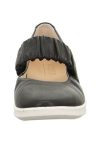 Czarne skórzane buty z marszczonym tekstylnym paskiem, zaokrąglonym czubkiem i białą podeszwą. Wnętrze wyłożone gładką beżową podszewką.