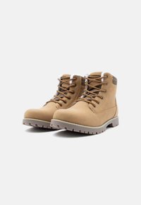 Brązowe skórzane botki na kostkę o gładkim wykończeniu, trwałej gumowej podeszwie i kontrastujących białych sznurowadłach, z wyściełanym kołnierzem i akcentami w postaci oczek.