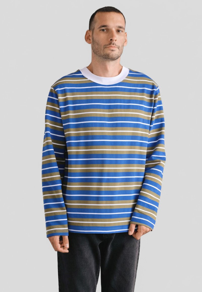 Koszulka z długim rękawem w niebieskie i brązowe paski, z białym okrągłym dekoltem. Wykonana z miękkiego materiału, z szerokimi poziomymi paskami na całym ciele.