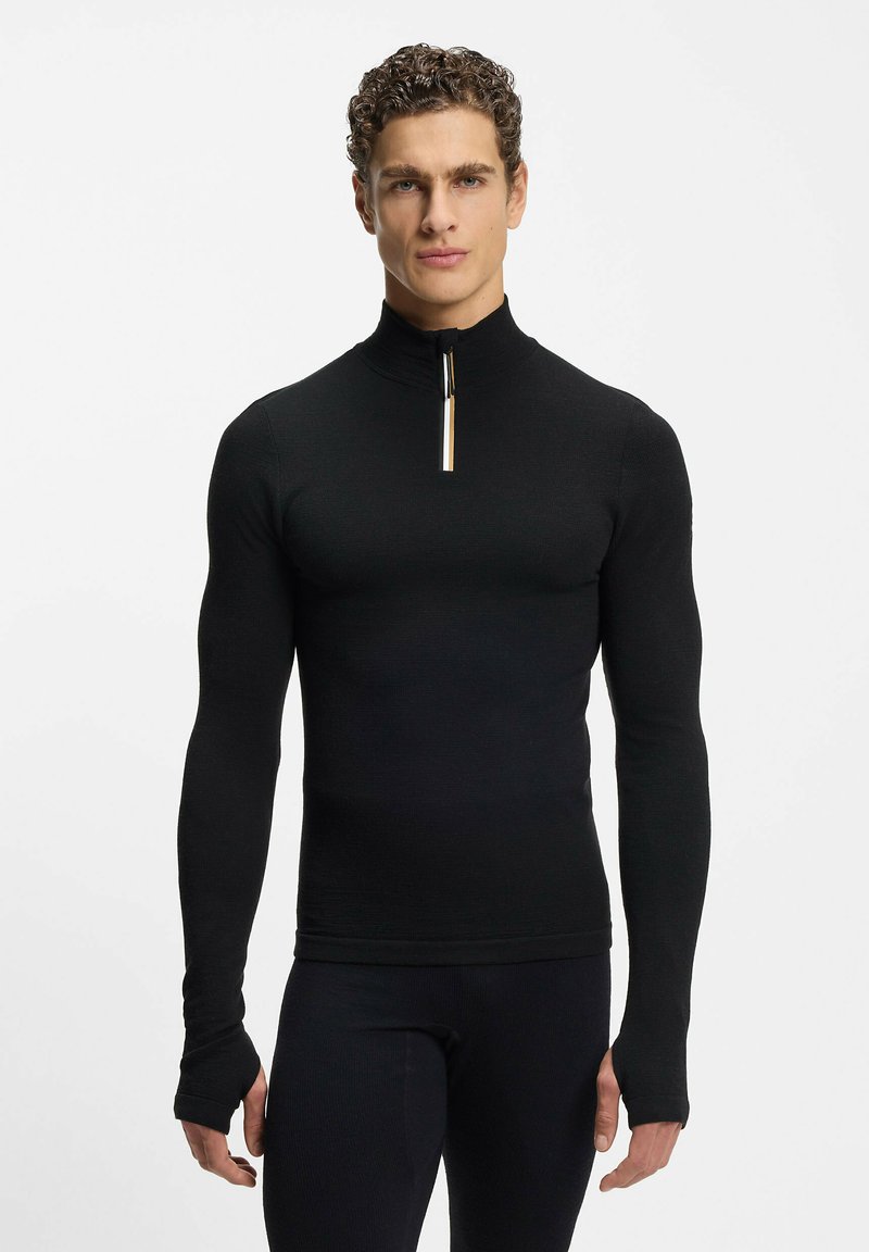 Czarny top z długim rękawem, z wysokim kołnierzem i ćwiartkowym zamkiem. Wykonany z gładkiej tkaniny, o dopasowanym kroju, z otworami na kciuki w mankietach.