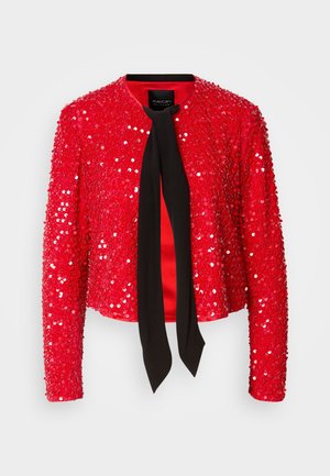 Veste à paillettes rouges avec un nœud en tissu noir au niveau du col. Elle possède des manches longues, un col rond et une surface brillante et texturée.