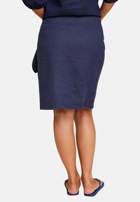 Marinblå linne blyantskjørt med rett snitt, knelengde design og en subtil tekstur. Inkluderer et sidesnøre detalj.