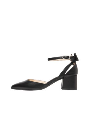 Zwarte leren pumps met spitse neus, enkelbandje en blokhak. Gladde textuur, minimalistisch ontwerp en een klein strikaccent bij de hak.