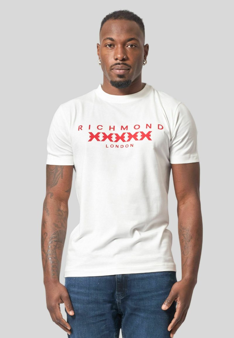 T-shirt bianca con design del testo e logo "RICHMOND" in rosso. Maniche corte, colletto rotondo e realizzata in morbido tessuto di cotone.