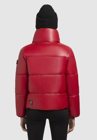 Rode pufferjack met hoge kraag, voorzien van een glanzende afwerking en een horizontaal quilted design. Inclusief zwart logo label aan de linkerkant.