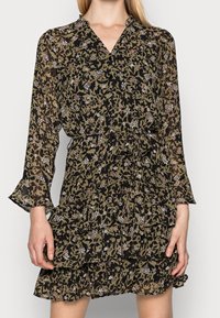 Vestido con estampado floral en verde oscuro y negro, confeccionado en una tela ligera. Presenta un dobladillo con volantes y mangas largas con escote en V.