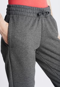 Grijze joggingbroek gemaakt van zachte stof, met een elastische tailleband met trekkoord, steekzakken aan de zijkant en een comfortabele pasvorm.