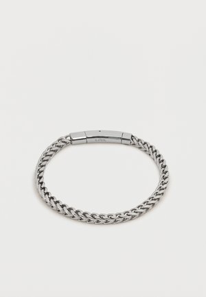 Zilverkleurige roestvrijstalen armband met een gepolijste rechthoekige sluiting waarop "S. STEEL" gegraveerd staat, op een effen witte achtergrond.