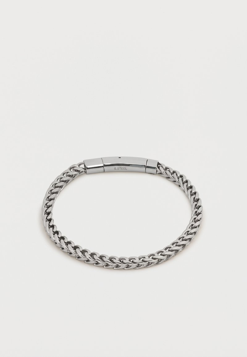 Bracelet chaîne en acier inoxydable argenté avec fermoir rectangulaire poli gravé "S. STEEL" sur fond blanc uni.