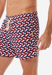 Pantaloni da nuoto con un motivo multicolore in rosso, bianco e blu, dotati di vita con cordino, realizzati in un tessuto morbido e con tasca laterale.