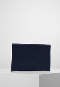 Borsa rettangolare in tessuto blu navy con una trama liscia, caratterizzata da linee pulite e senza accessori o motivi visibili.
