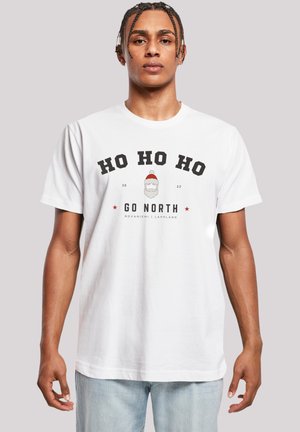 White cotton t-shirt featuring a graphic print with "HO HO HO" text, a Santa illustration, and "GO NORTH" in bold black letters beneath.