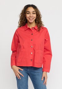 Röd, bomullsjacka med krage, tryckknappar framtill och två framfickor. Har en avslappnad passform och långa ärmar.