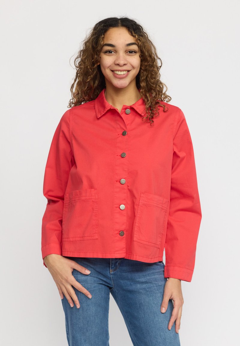 Röd, bomullsjacka med krage, tryckknappar framtill och två framfickor. Har en avslappnad passform och långa ärmar.