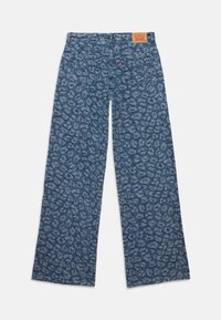 Jeans de perna larga com estampa de leopardos azul, com bolsos traseiros, um emblema de marca em pele e uma etiqueta vermelha da Levi's no bolso direito.