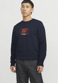 Marine crewneck sweatshirt van katoen, met een centrale zwart-rode grafische print met "JACK & JONES." Ribgebreide manchetten, relaxte pasvorm.