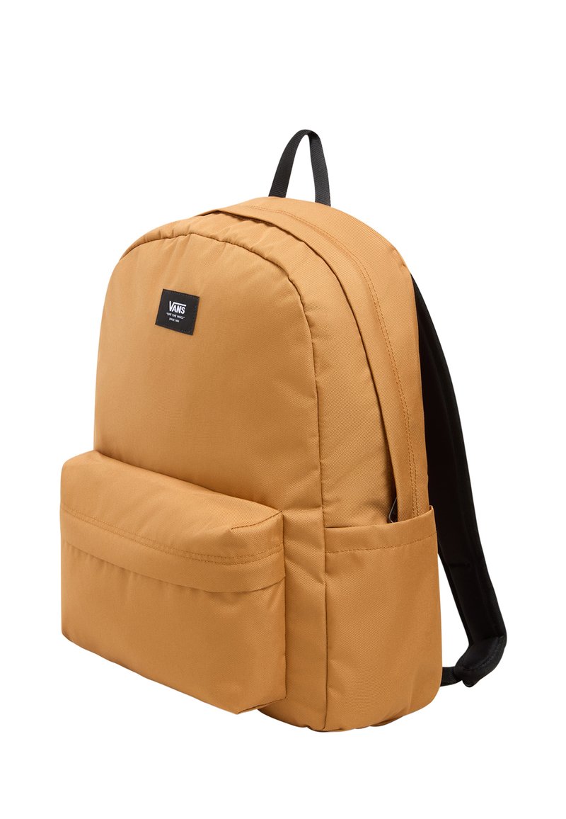 Mochila de lona naranja con forma redondeada, correas negras y un bolsillo delantero. Presenta un parche con logo y una tela de textura suave.