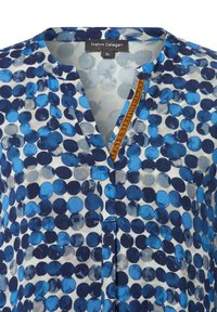 Blusa con motivo a pois blu e navy, con scollatura a V e un dettagli in velluto marrone sul davanti.