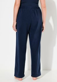 Laivaston siniset fleece-housut, joissa on joustava vyötärö, suora lahjemuotoilu ja pehmeä rakenne, ominaisuutena yksinkertainen, tasaväri ilman kuvioita.