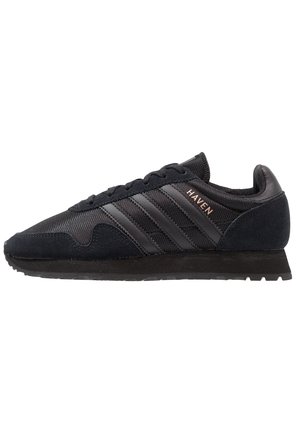 Czarny niskoprofilowy sneaker z teksturowanej tkaniny, zamszowymi akcentami, trzema czarnymi paskami i napisem "HAVEN" po boku.