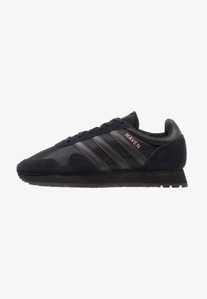 Czarny niskoprofilowy sneaker z teksturowanej tkaniny, zamszowymi akcentami, trzema czarnymi paskami i napisem "HAVEN" po boku.