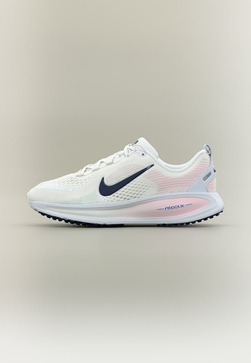 Chaussure de course Nike blanche avec swoosh noir, tige en mesh respirant, accents rose pâle et semelle en mousse React sur fond neutre.