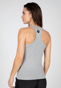 Heathergrijze tanktop met een racerback-design en een klein zwart gorilla-logo aan de achterkant. Zachte stof met een getailleerde pasvorm.
