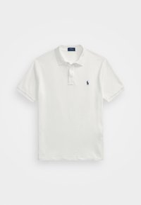 Polo blanc en coton. Dispose d'un col à revers, de trois boutons et d'un petit logo bleu marine sur le côté gauche de la poitrine. Manches courtes.