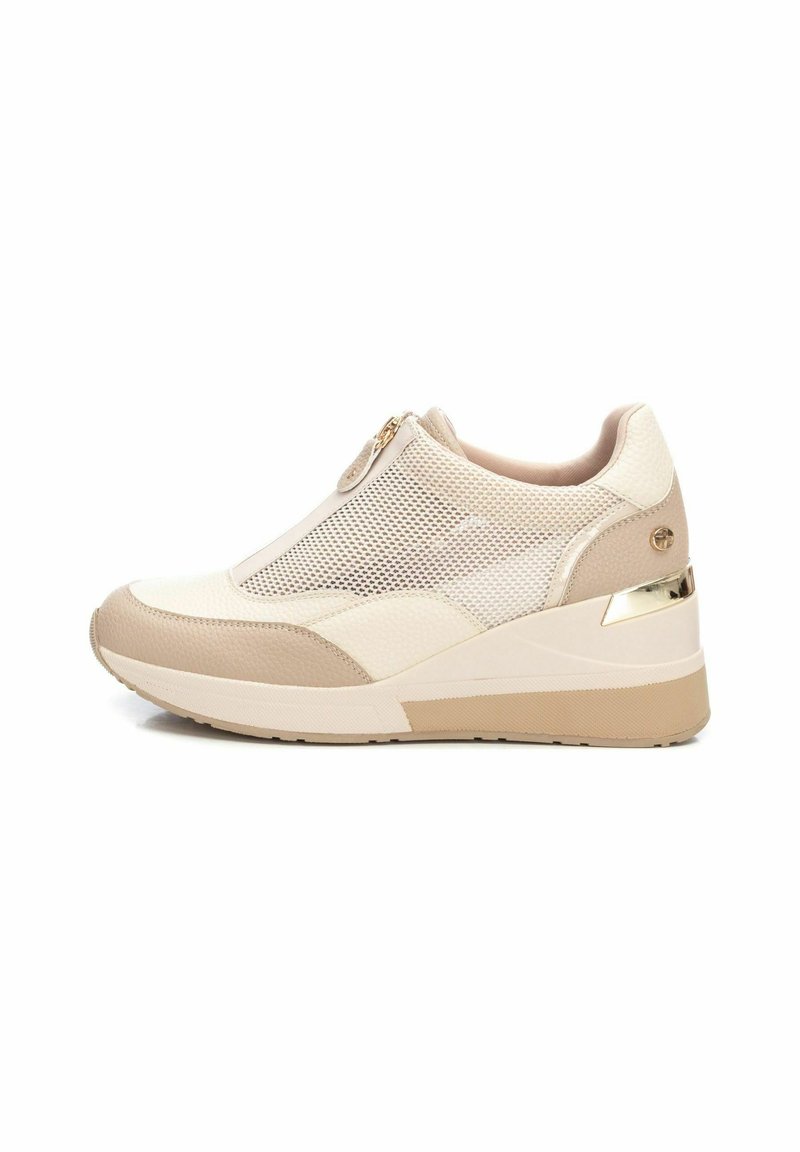 Sneaker beige con tomaia in rete, dettagli in pelle e una zip color oro. La suola a zeppa presenta un design testurizzato per maggiore grip.