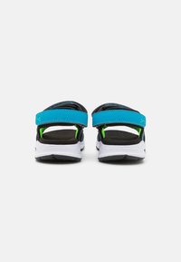 Schwarze Sandalen mit blauen Riemen und grünen Akzenten, ausgestattet mit einem bequemen Fußbett und einer strukturierten Sohle, die für den Outdoor-Gebrauch entworfen wurden.