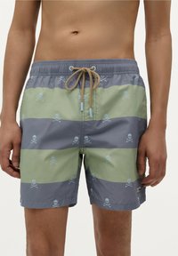Short de bain rayé gris et vert avec un motif de tête de mort et os croisés bleu clair. Equipé d'une taille élastique et d'un cordon de serrage.