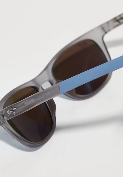 Szare plastikowe okulary przeciwsłoneczne z ciemnymi soczewkami i jasnoniebieskimi akcentami na zausznikach. Posiadają gładką teksturę oraz logo na jednym z zauszników.