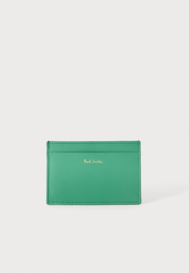 Porte-cartes en cuir vert avec deux compartiments pour cartes et logo doré "Paul Smith" centré sur le devant sur un fond clair uni.