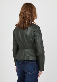 Grön läderjacka med en figursydd design, peplum-hamn och strukturerade sömmar. Bakvy visar en slät yta och något puffiga ärmar.