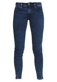 Tajta jeans i mörkblå denim, med midjehöjd, framfickor och dragkedjor vid anklarna för justerbar passform och stil.