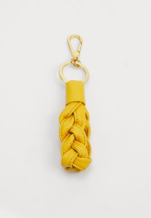 Porte-clés en cuir jaune avec un design tressé et un fermoir et un anneau en métal doré. Texture lisse avec des détails de couture visibles.
