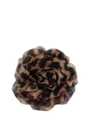 Accessoire fleur en tissu avec des pétales superposés dans un motif léopard brun foncé et noir sur fond blanc.