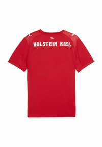 Rød sporty skjorte med korte ærmer, der har "HOLSTEIN KIEL" i hvid tekst på ryggen og et logo på forsiden af skulderen.