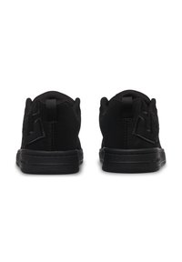 Chaussures de sport noires avec une tige en suède texturé, un col rembourré et un talon renforcé avec des coutures ton sur ton et des détails de marque.