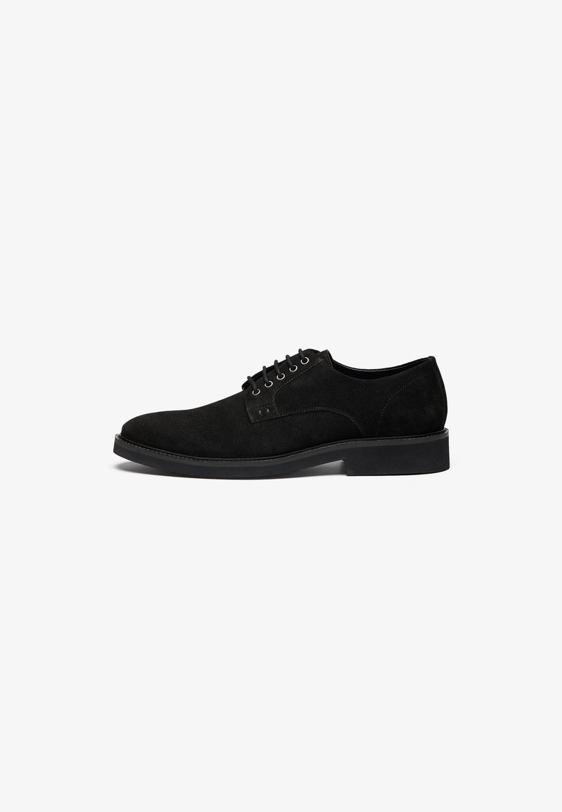 Black suede lace-up shoes with a rounded toe, flat sole, and minimal stitching details. Features six eyelets and a smooth matte finish.