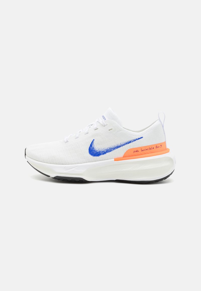 Witte sportieve schoen met ademend gebreid bovenwerk, blauwe swoosh, zwarte buitenzool en oranje accent op de middenzool. Voorzien van gestikt detail en vetersluiting.