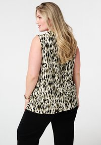 Mouwloos topje in een beige en zwart dierenprint, met een relaxte pasvorm en textuurstof, voorzien van een ronde halslijn en subtiele plooien.
