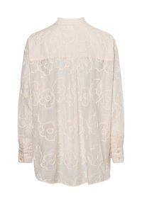 Helle Bluse mit floralem Stickmuster, weicher Textur, langen Ärmeln und durchgehender Knopfleiste. Verfügt über einen klassischen Kragen.