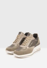Sneaker aus einer Kombination von glattem und Wildleder in grau-braunen Materialien, mit einer dicken weißen Sohle, abgerundeter Form und kontrastierenden Akzenten.