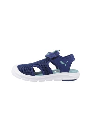 Sandalia infantil Puma azul marino con parte superior de malla, tira ajustable con velcro, logo azul claro, plantilla acolchada color azul verdoso y suela blanca flexible.