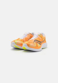 Bright orange athletic shoes with white accents, mesh upper, and a cushioned sole. Features a distinctive logo and textured patterns on the surface.