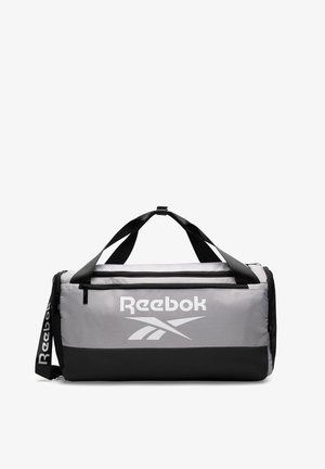 Szaro-czarna torba sportowa Reebok z podwójnymi czarnymi uchwytami, zamykanymi na zamek przegrodami oraz paskiem na ramię z logo marki.