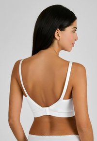 Reggiseno bianco con una texture liscia, spalline regolabili e chiusura a gancio sul retro. Design semplice con silhouette a schiena bassa.